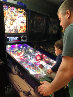 Ryan Greenwell with son and pinball machine